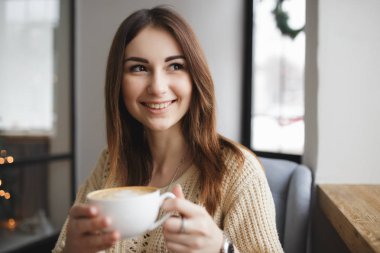 Fincan kahve bir kafe ve pencere göz ile oturan kadın