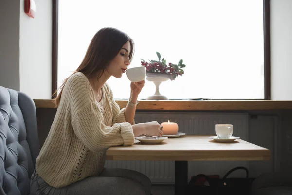 Милая женщина пьет чашку кофе в кафе — стоковое фото