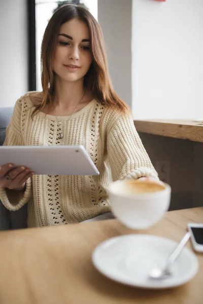 Зайнята жінка бере чашку капучино в кафе — стокове фото