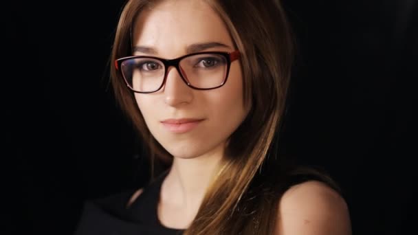 Closeup of attractive woman wearing eyeglasses at black background — Stock Video