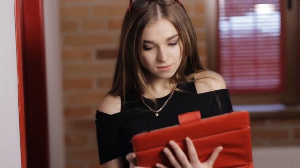 Aantrekkelijke jonge vrouw met rode tablet Pc op kamer — Stockvideo