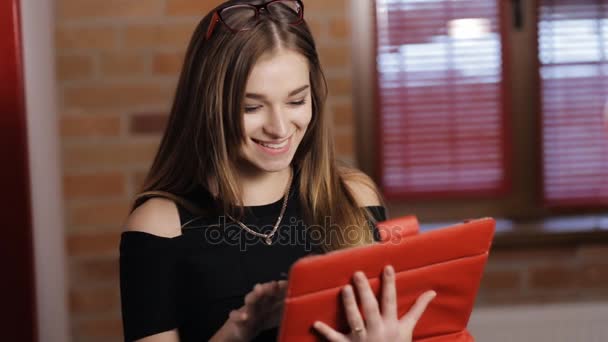 Привлекательная молодая женщина с красным планшетным ПК в номере — стоковое видео