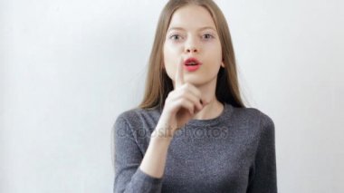 Genç kız beyaz arka plan üzerinde Hush jest yapıyor