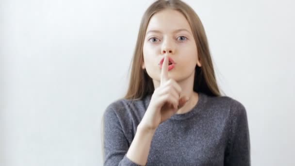 Menina adolescente fazendo gesto de silêncio no fundo branco — Vídeo de Stock