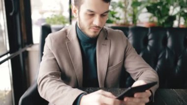 Bir kafede dijital tablet kullanarak başarılı bir iş adamı