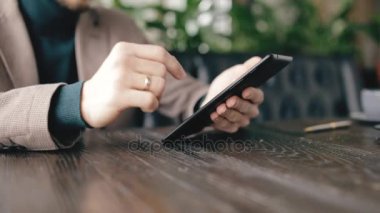 Bir kafede dijital tablet kullanarak işadamı kırpılmış