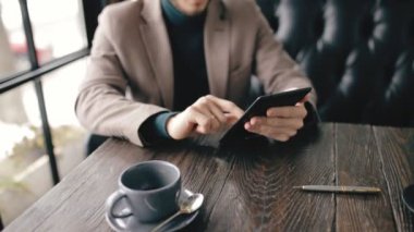 Bir kafede dijital tablet kullanarak başarılı bir iş adamı