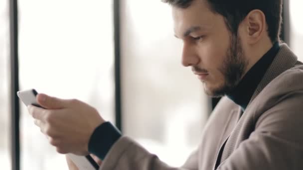 Vista de perfil del exitoso hombre de negocios usando tableta digital en un café — Vídeos de Stock