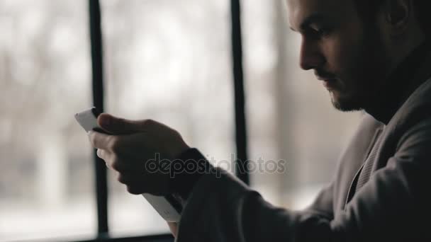 Vista de perfil del exitoso hombre de negocios usando tableta digital en un café — Vídeo de stock