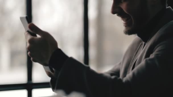 Vista de perfil del exitoso hombre de negocios usando tableta digital en un café — Vídeo de stock