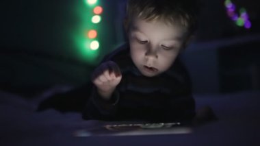 Tablet pc veya smartphone yatakta ile geceleri oynarken küçük çocuk