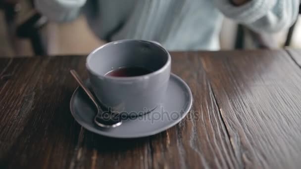 Mujer primer plano echando azúcar a la taza de café en un café — Vídeos de Stock