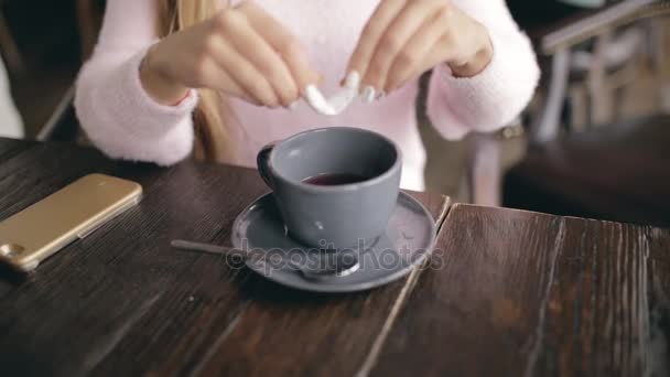 Donna divertente che spargeva zucchero a tazza di caffè in un caffè — Video Stock