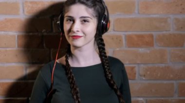 Kulaklık dinlemek müzik tuğla duvar karanlık odada, kadında