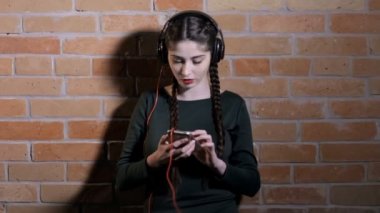 Kulaklık dinlemek müzik tuğla duvar karanlık odada, kadında