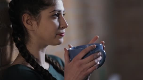Kadın içme çay, tuğla duvar arka planda karanlık oda — Stok video