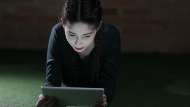 Donna che utilizza tablet PC sdraiato sul pavimento di notte — Video Stock