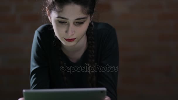 Donna che utilizza tablet PC sdraiato sul pavimento di notte — Video Stock