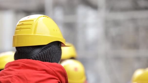 Des gens méconnaissables dans des casques sur une usine extérieure — Video