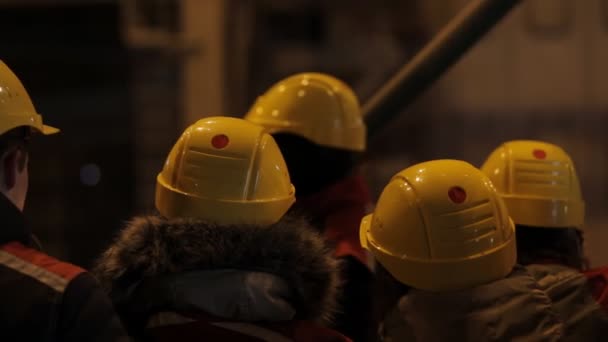 Неузнаваемые люди в шлемах на фабрике — стоковое видео