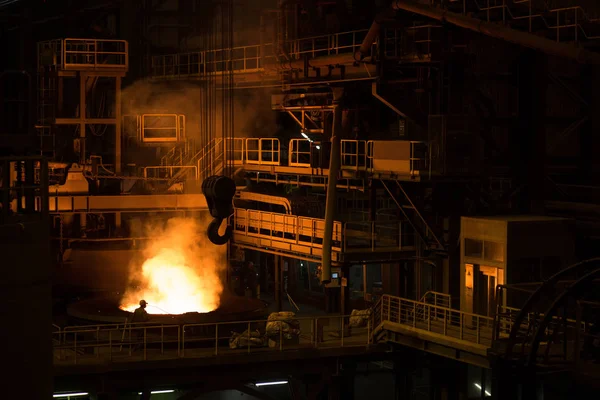 Metallurgical plant, liquid metal in container. Big crane hook.