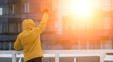 Eller yukarıda şehir güneş ışığı ile başarılı adam