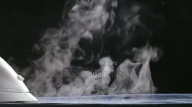 Siyah arka plan üzerine Buhar ile demir yumuşatma. Kot Ütü.