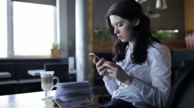 Modern nesil. Latte cools ise kafede smartphone kullanan kadın.
