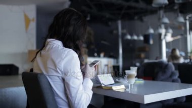 Tanınmayan kadın latte cools ise kafede smartphone kullanarak