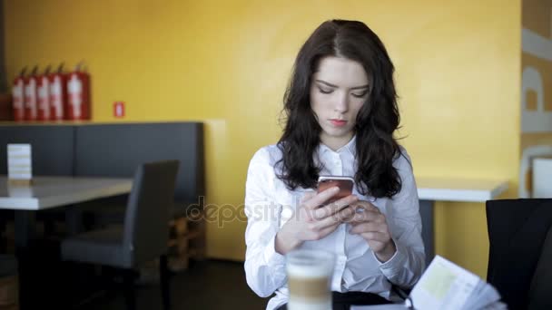 Generación moderna. Mujer usando teléfono inteligente en la cafetería, mientras que el café con leche se enfría . — Vídeo de stock