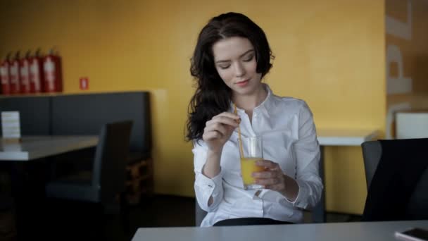Молодая женщина пьет свежий сок в кафе — стоковое видео