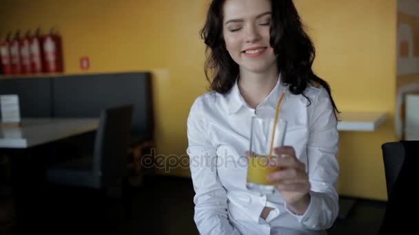 Mujer divertida clink vasos con jugo fresco en la cafetería — Vídeos de Stock