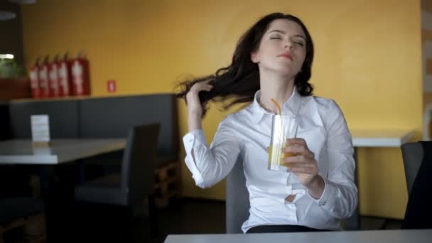 Молода жінка п'є свіжий сік у кафе — стокове відео