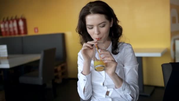 Mujer bonita bebiendo jugo fresco en la cafetería — Vídeos de Stock