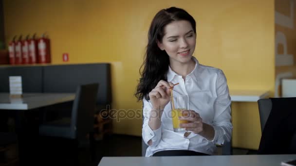 Mujer bonita bebiendo jugo fresco en la cafetería — Vídeo de stock