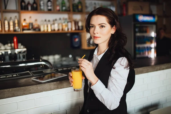 Giovane donna che tiene un bicchiere di succo d'arancia fresco al bar del ristorante. Tendenza sanitaria . — Foto Stock
