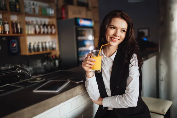 Note di alimentazione - giovane donna che tiene il succo d'arancia al bar del ristorante — Foto Stock