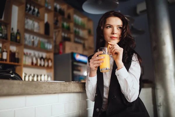 Note di alimentazione - giovane donna che tiene il succo d'arancia al bar del ristorante — Foto Stock