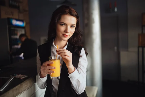 Note di alimentazione - ritratto di una giovane donna che tiene il succo d'arancia al bar del ristorante — Foto Stock