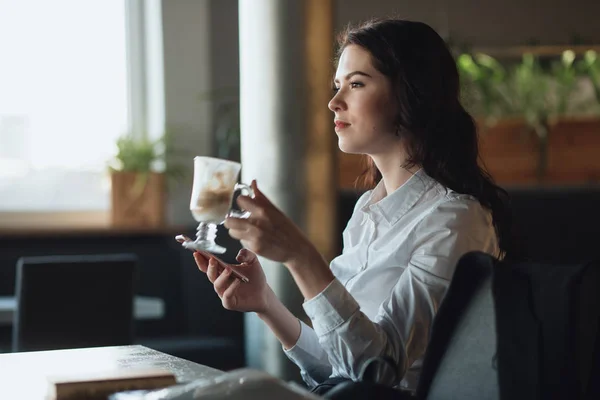 Ділова жінка читає новини на смартфоні, використовуючи додаток пити латте в кафе — стокове фото