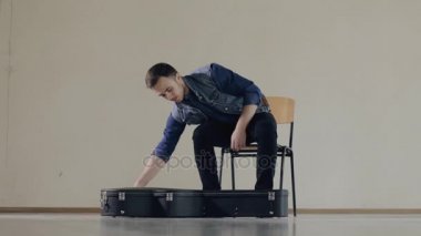 Gitarist bir gitar durumda dışarı alır ve oynamaya başlar