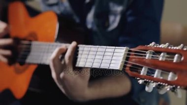 Akustik gitar gri duvar arka plan oturan oynarken gitarist closeup