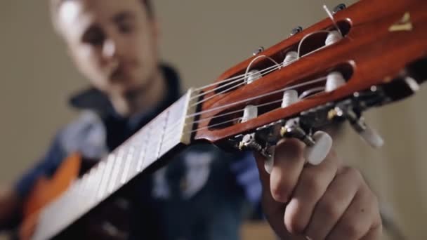 Guitarrista afinando la guitarra acústica — Vídeos de Stock