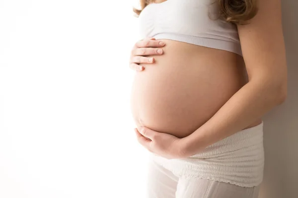 Przycięte zdjęcie kobiety w ciąży z duży brzuch na białym tle — Zdjęcie stockowe