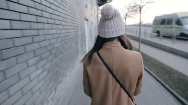 Genç kadın şehirde yürüyüş sırasında smartphone cep telefonu ile mesaj yazarken