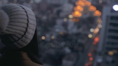 Akşam cityscape için yüksek gökdelen arayan kadın. Şehir gece ışıkları.