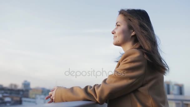 Menina relaxada olhando para a frente ao pôr do sol na cidade — Vídeo de Stock