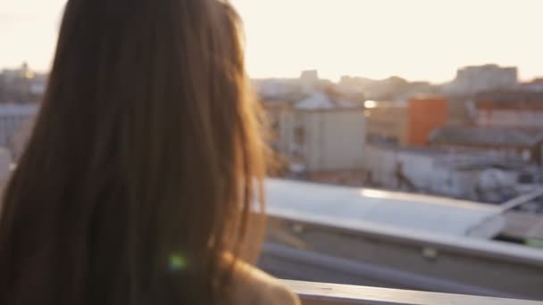 Onbekende vrouw in dak op zoek naar stad zonsondergang — Stockvideo