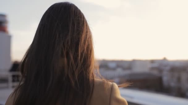 Неопознанная женщина фотографирует на своем смартфоне на городском закате — стоковое видео