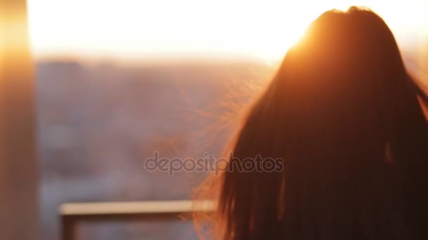 Молодая женщина фотографирует город на закате с небоскреба — стоковое видео